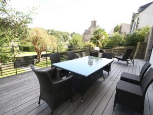 Un patio con una mesa y sillas en una terraza. en Luxurious Villa in Pont-Aven with Private Pool, en Pont-Aven