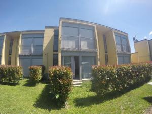 an apartment building with bushes in front of it at Camping Villaggio Paradiso in Domaso