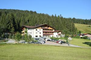 a large building with cars parked in a parking lot at Ferienhotel Iris in Auffach