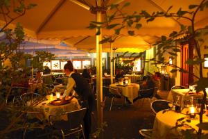 a woman standing in front of a restaurant with tables at Hotel Zofingen in Zofingen +16 photos