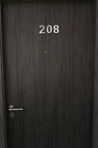 a wooden door with the number on it at Stay in Style at Nimman R208 in Chiang Mai