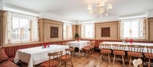 a restaurant with two tables and chairs and windows at Guesthouse Avsenik in Begunje na Gorenjskem