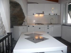 a kitchen with white cabinets and a counter top at Cegi's home in Vernazza