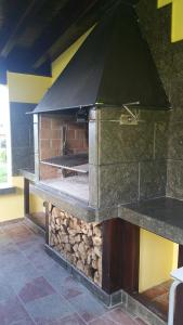 um grande forno de pedra com uma pilha de madeira em Casa de Aldea El Frade em Camango