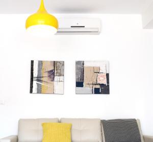 a living room with a couch and a yellow lamp at El Jardin BeNerja in Nerja