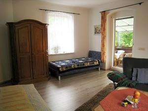 a living room with a bed and a window at Hotel-Pension Königswald in Dresden