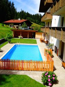 a swimming pool in a yard next to a house at Ferienhotel Iris in Auffach