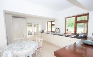 a white kitchen with a table and a counter top at Luskin's in Cong +26 photos