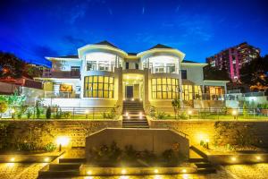 キガリにあるThe Court Boutique Hotelの夜の灯りを持つ大きな白い家