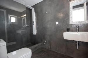 a bathroom with a white toilet and a sink at Anixi Lounge Suites - Adults Only in Ornos +75 photos