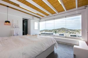 a bedroom with a large bed and a large window at Anixi Lounge Suites - Adults Only in Ornos