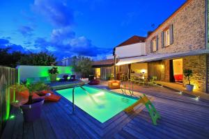 a backyard with a swimming pool and a wooden deck at Résidence La Chaize in Noirmoutier-en-l'lle