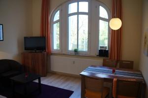 ein Wohnzimmer mit Tisch und großem Fenster in der Unterkunft Ferienwohnung Sandrose in Wangerooge
