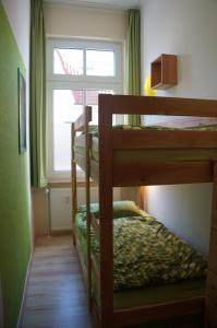 2 Etagenbetten in einem kleinen Zimmer mit Fenster in der Unterkunft Ferienwohnung Sandrose in Wangerooge
