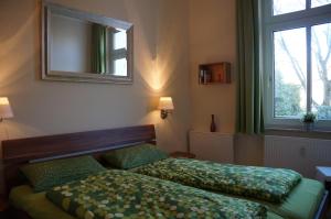 1 Schlafzimmer mit 2 Betten, einem Spiegel und einem Fenster in der Unterkunft Ferienwohnung Sandrose in Wangerooge