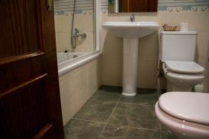 阿德拉的住宿－Hostal Restaurante La Curva，浴室配有卫生间、盥洗盆和浴缸。