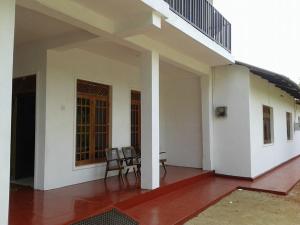 eine Veranda eines Hauses mit zwei Stühlen und einem Tisch in der Unterkunft Didula Holiday Resort in Anuradhapura