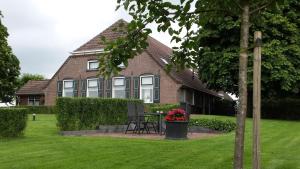 una casa con una mesa y sillas frente a ella en Hof Van Lenthe appartementen en Dalfsen