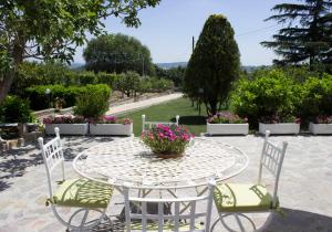 a table and chairs with flowers on a patio at Le3sorelle in Monterosi
