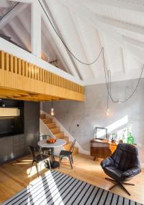 a living room with a table and chairs and a staircase at Gold & Grey Loft Almada in Porto