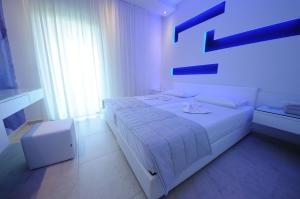 a white bedroom with a white bed and a window at Louloudis Fresh-Adults Only in Skala Rachoniou
