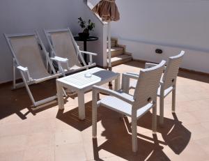 a white table and chairs in a room at Marine House Andrianna -Adults only in Siviri