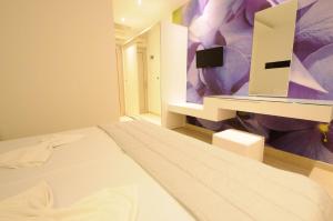 a bedroom with a bed and a mirror at Louloudis Fresh-Adults Only in Skala Rachoniou