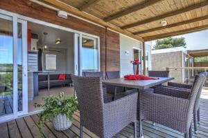 a patio with a table and chairs on a deck at Camp Rehut in Murter