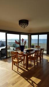 a dining room with a table and chairs and a view of the ocean at V.I.P. Baia in Machico