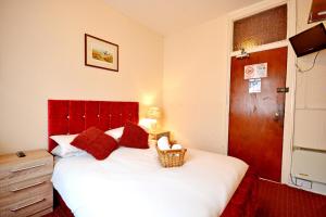 1 dormitorio con 1 cama grande y cabecero rojo en The Derby Hotel, en Blackpool