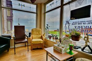 a living room with a view of the ocean through the windows at The Derby Hotel in Blackpool