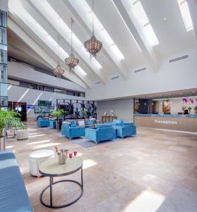 a lobby with blue chairs and tables in a building at Lagoon Beach Hotel & Spa in Cape Town