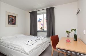 a bedroom with a bed and a table and a window at Kalmar Hotell in Kalmar