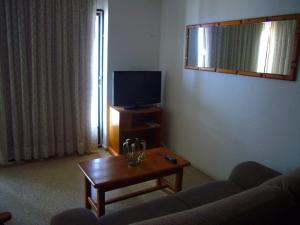 uma sala de estar com um sofá e uma mesa com uma televisão em Mar y Vent - Fincas Arena em Benidorm