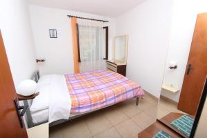 mała sypialnia z łóżkiem i lustrem w obiekcie Apartments Palaziol w Rovinj