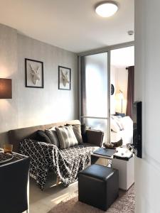 un soggiorno con un divano e un letto di Stay in Style at Oasis a Chiang Mai