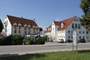 eine Reihe weißer Gebäude auf einer Straße in der Unterkunft Flair Hotel Zum Schwarzen Reiter in Horgau