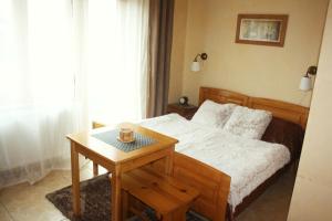 a bedroom with a bed and a table with a cup on it at Penzion Svojše in Český Krumlov