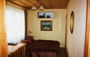 a bedroom with a bed and a desk and a window at Penzion Svojše in Český Krumlov