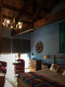 a bedroom with a bed and a table and a chandelier at Os Tres Teixos in San Acisclo