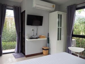 a bedroom with a bed and a tv on the wall at The Focus Khaoyai Resort in Mu Si