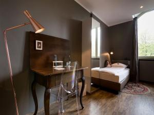 a bedroom with a desk with a bed and a desk at Hotel Heimathafen in Lörrach