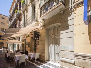 a restaurant with tables and chairs on the side of a building at Atlas in Málaga