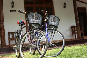 duas bicicletas com cestas estacionadas em frente a uma casa em Amsterdam Tourist Rest em Anuradhapura