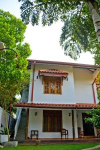 ein weißes Haus mit rotem Dach in der Unterkunft Amsterdam Tourist Rest in Anuradhapura