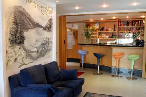 a living room with a blue couch and a bar at Hotel Florida in Molveno
