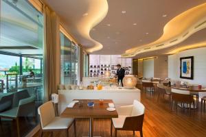 a restaurant with tables and chairs and a chef in the background at The View Lugano in Lugano