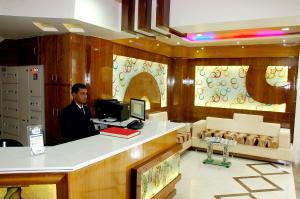 a man standing at a counter in a store at Hotel Merit in Surat