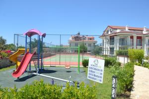 a playground with a tennis court in front of a house at Korfez Life Apartments in Fethiye