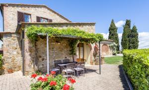een terras met een tafel en stoelen voor een gebouw bij Monti 1824 - Apartments & Cottages in Casole dʼElsa